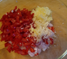 A bowl with shallots, garlic, chili peppers, laos, ginger and some trassi