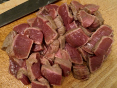 The thin slices of seared beef on the cutting board