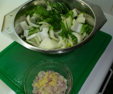 Chopped Pak Choi in a colander and shallots and garlic in a bowl